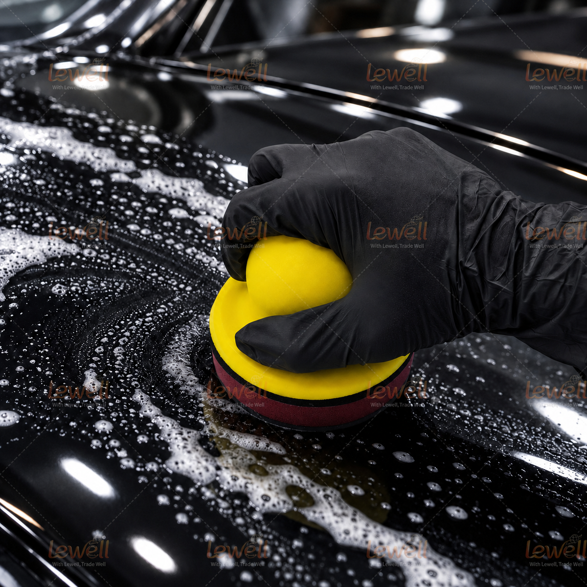 Gloved hand using a yellow foam handheld sanding block on a textured surface