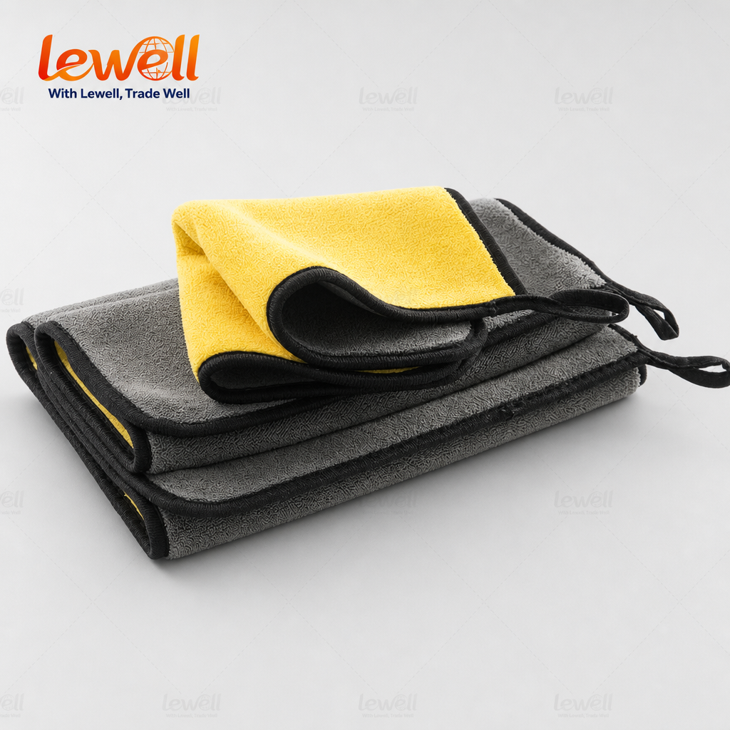 Folded grey and yellow coral fleece detailing towels with black trim and tie loop