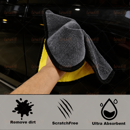 Grey and yellow coral fleece towel with black edge, held up to show plush pile